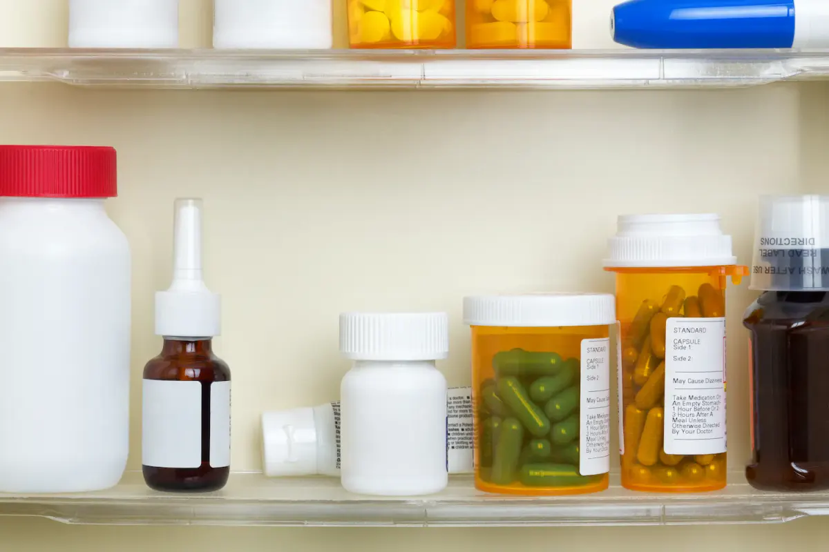 A medicine cabinet filled with various prescription pill bottles, illustrating the importance of safely disposing of leftover or expired medications during National Prescription Drug Take Back Day to prevent misuse.