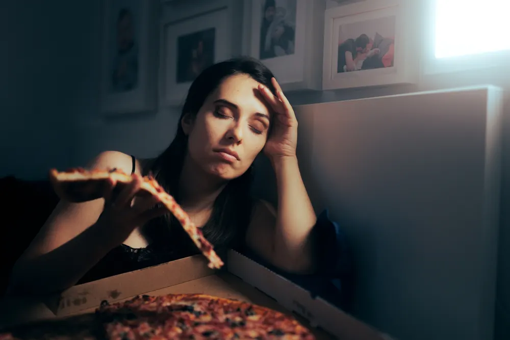 stressed-tired-woman-eating-pizza-eating-disorder-registered-dietitian-vitamins-and-minerals-improve-mood-kidney-disease-medical-nutrition-therapy