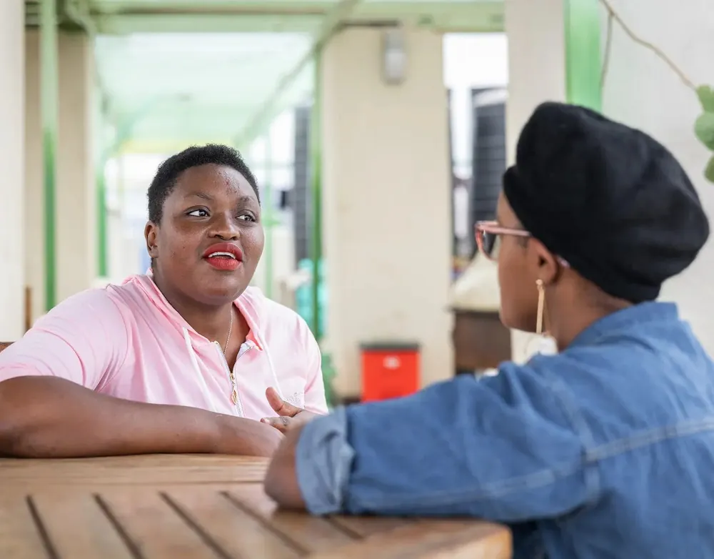 Two women talking at an outdoor table