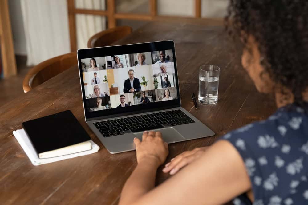 Female employee engaging in online support groups for substance abuse highlighting the ease of access through digital virtual meetings with diverse colleagues