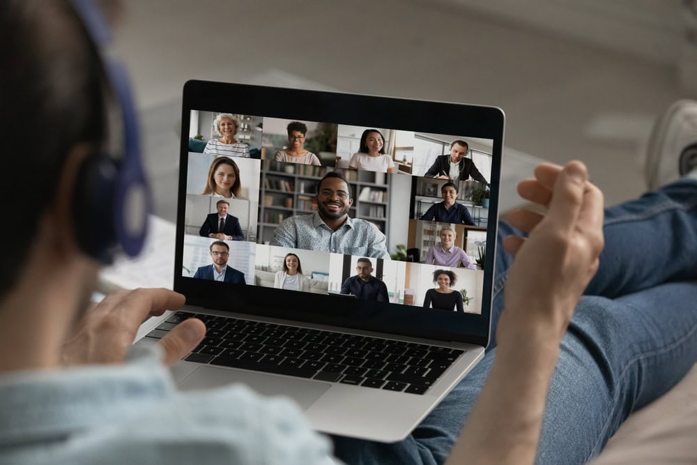 Male employee engaged in online support groups for substance abuse utilizing the ease of access to have a digital conference with diverse colleagues